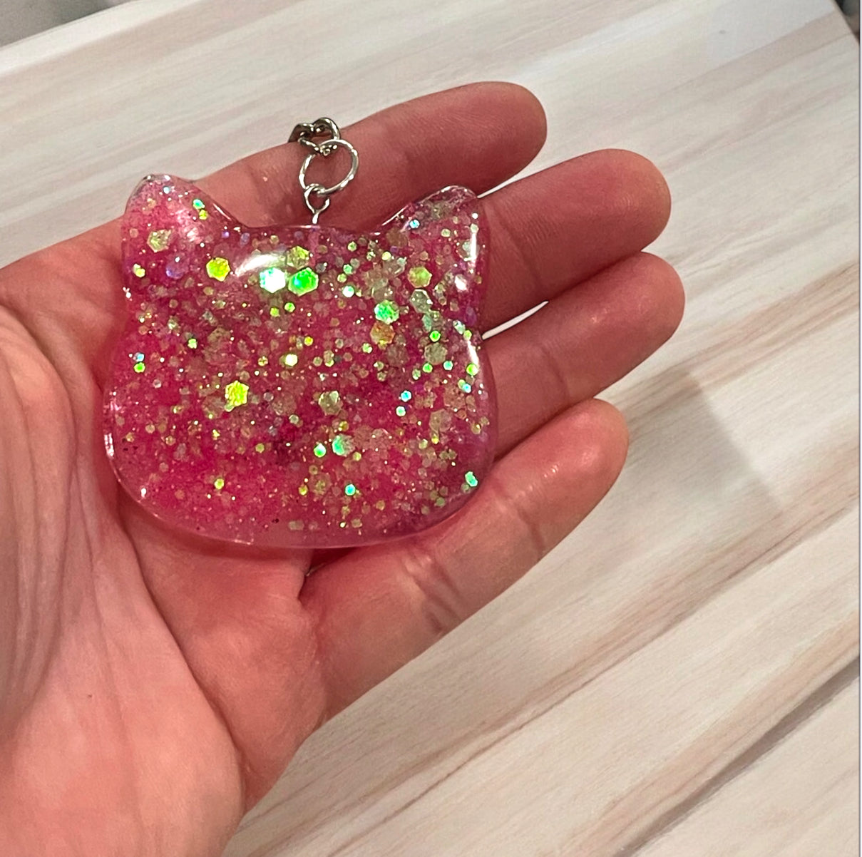 Handmade pink cat head keychain with holographic glitter and iridescent hexagons in crystal clear resin, perfect for cat lovers and pet parents