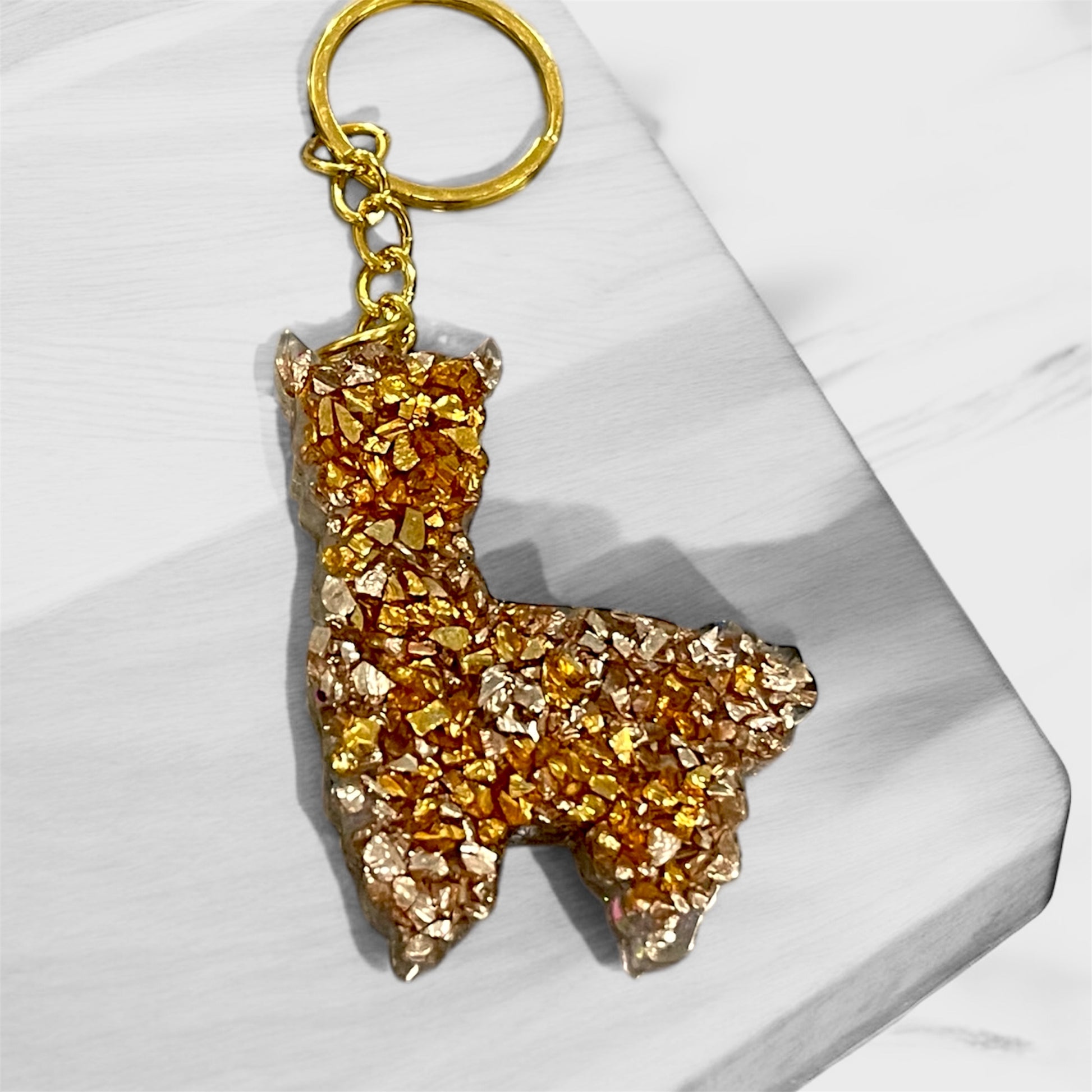 Handmade llama resin keychain with delicate pink and iridescent glitter, featuring gold hardware and whimsical design